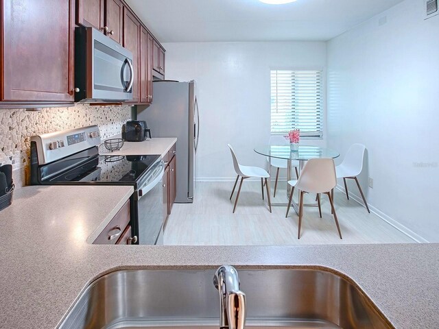 kitchen featuring stainless steel appliances and light hardwood / wood-style flooring