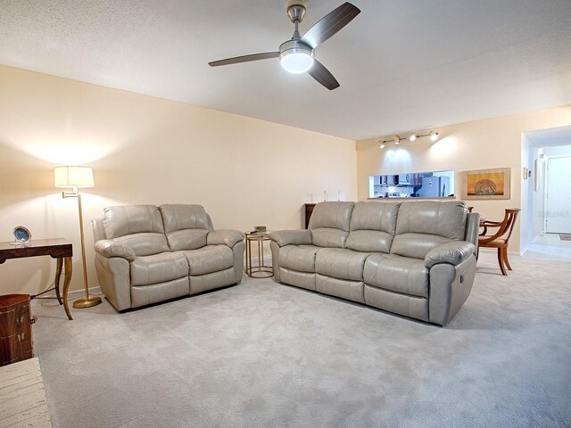 carpeted living room with ceiling fan