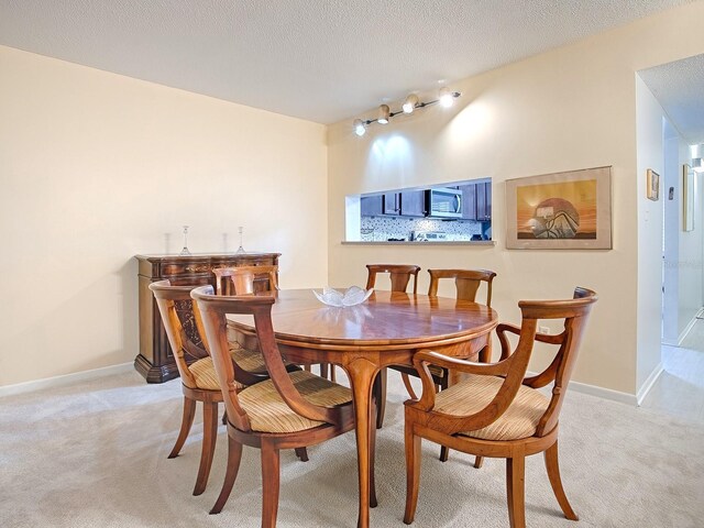 carpeted dining space featuring a textured ceiling