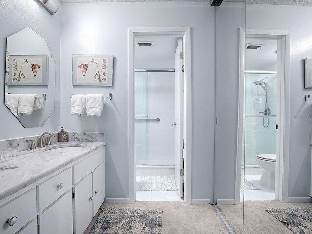 bathroom with vanity, toilet, and an enclosed shower