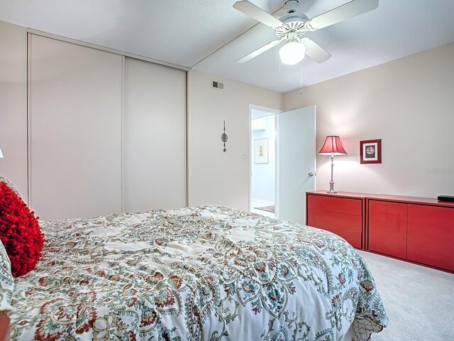 bedroom with a closet, ceiling fan, and carpet flooring