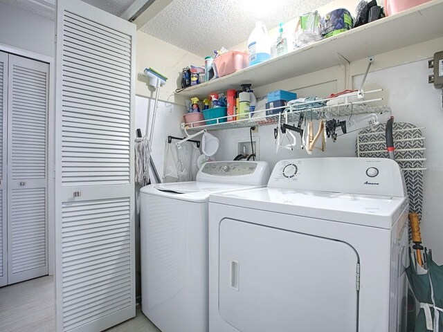 clothes washing area with a textured ceiling and washing machine and clothes dryer