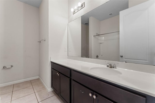 full bathroom featuring a shower, tile patterned flooring, vanity, and baseboards