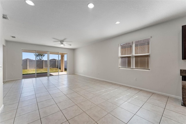 unfurnished room featuring light tile patterned floors, ceiling fan, visible vents, and baseboards