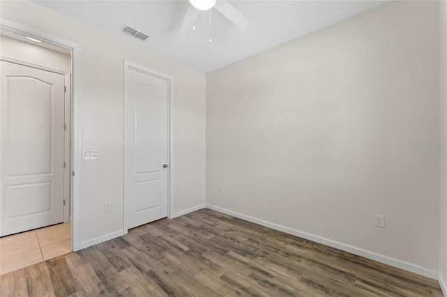 unfurnished bedroom with baseboards, visible vents, ceiling fan, and wood finished floors