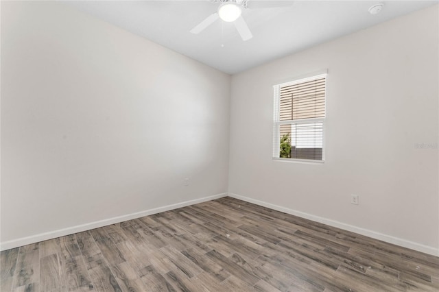 empty room featuring ceiling fan, wood finished floors, and baseboards