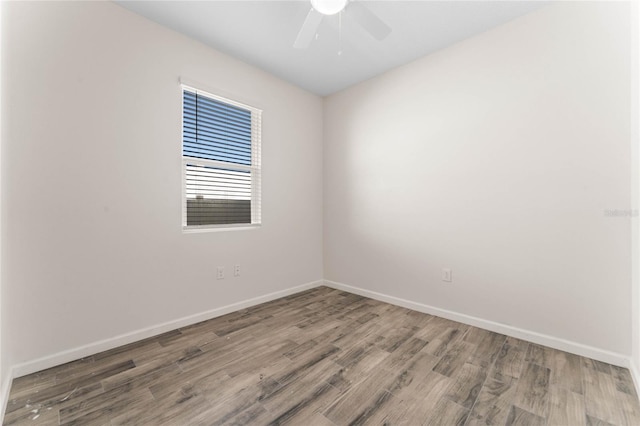 spare room featuring ceiling fan, baseboards, and wood finished floors