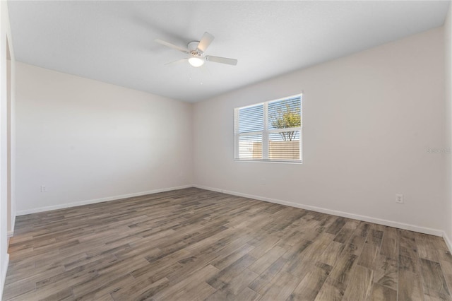 empty room featuring ceiling fan, baseboards, and wood finished floors