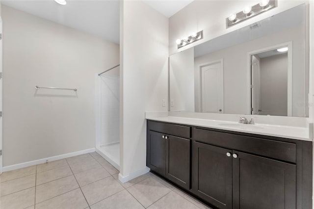 full bathroom with visible vents, baseboards, vanity, a tile shower, and tile patterned floors