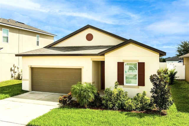 view of front of home featuring a garage, driveway, a front lawn, and stucco siding