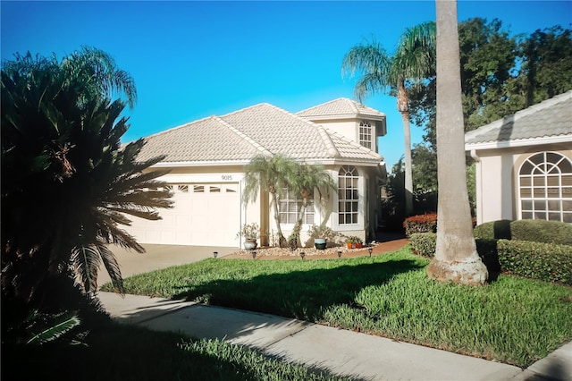 mediterranean / spanish home with a garage and a front lawn