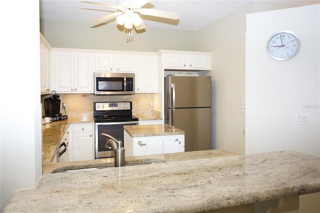 kitchen with white cabinets, appliances with stainless steel finishes, and tasteful backsplash