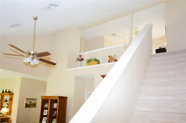 stairs with a high ceiling and ceiling fan