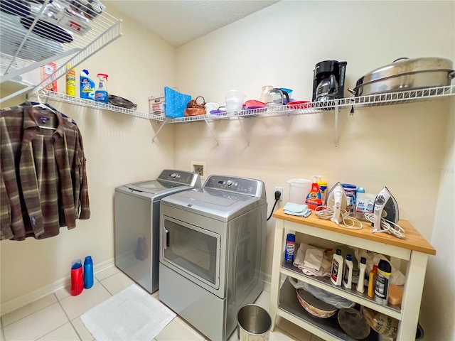 laundry area featuring washer and clothes dryer and light tile patterned flooring