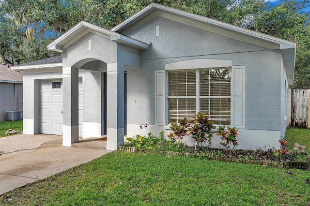 view of front of property featuring central air condition unit, a garage, and a front yard