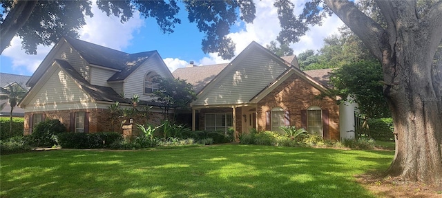 view of front of home with a front yard and brick siding