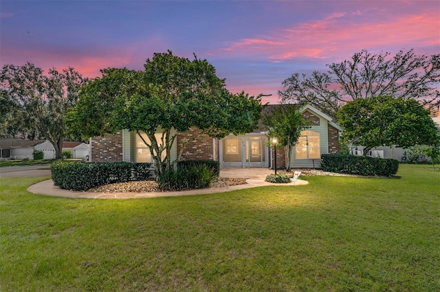 view of front of property with french doors and a yard