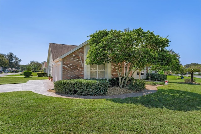 view of home's exterior with a garage and a lawn