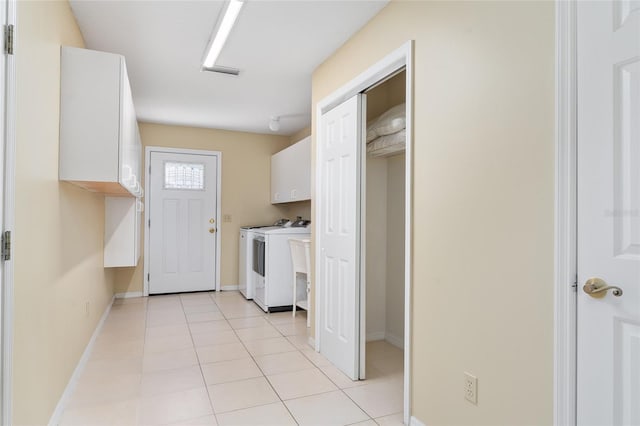 washroom with washer and dryer, cabinets, and light tile patterned floors