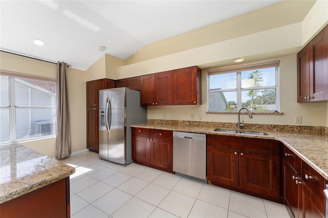 kitchen featuring sink, light tile patterned flooring, stainless steel appliances, vaulted ceiling, and light stone counters