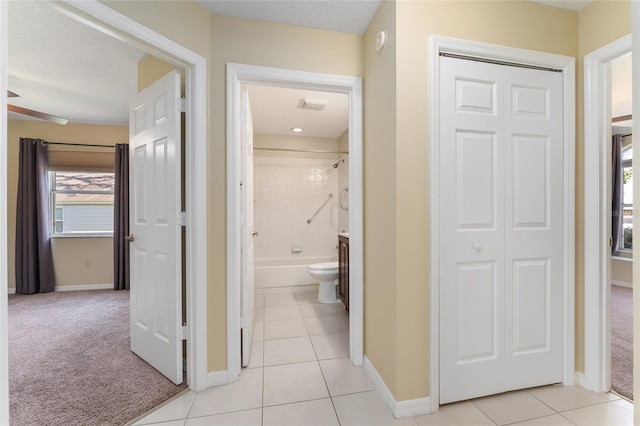 hall with a textured ceiling and light colored carpet