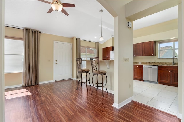 kitchen with light wood-type flooring, dishwasher, plenty of natural light, and decorative light fixtures