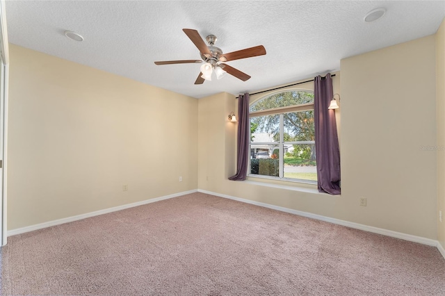 spare room with ceiling fan, carpet flooring, and a textured ceiling