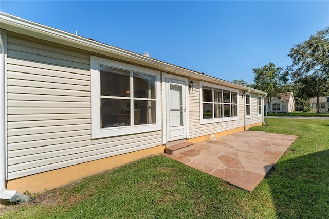 rear view of house featuring a patio area and a lawn