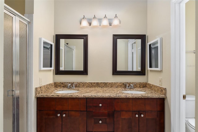 bathroom with vanity, toilet, and an enclosed shower