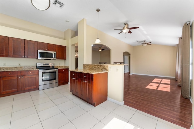 kitchen with ceiling fan, light stone countertops, stainless steel appliances, light hardwood / wood-style floors, and decorative light fixtures