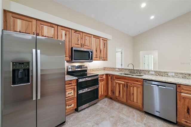 8222 Florida Boys Ranch Rd, Groveland, FL 34736 - kitchen with brown cabinets, light stone counters, a sink, stainless steel appliances, and lofted ceiling
