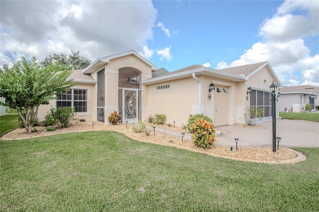 single story home with a garage, a sunroom, and a front lawn