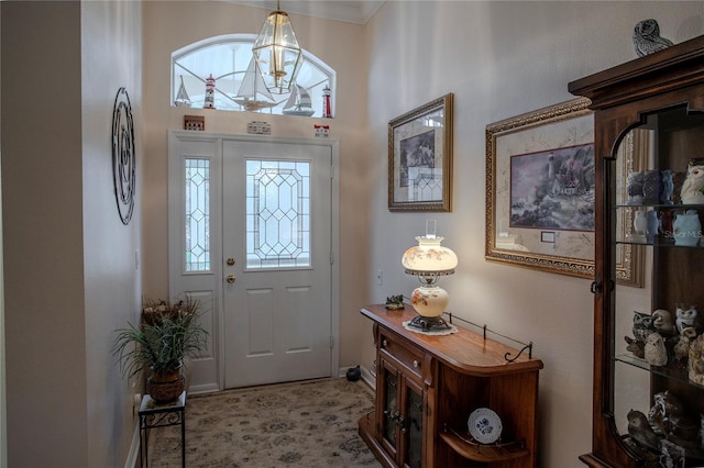 foyer featuring an inviting chandelier and ornamental molding