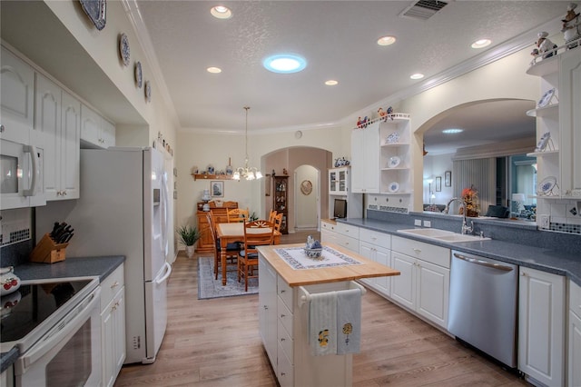 kitchen featuring wooden counters, white appliances, crown molding, sink, and white cabinets