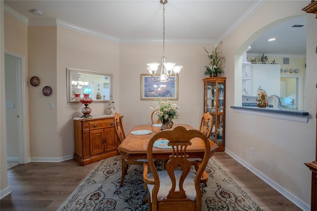 dining area with wood-type flooring, a notable chandelier, and ornamental molding