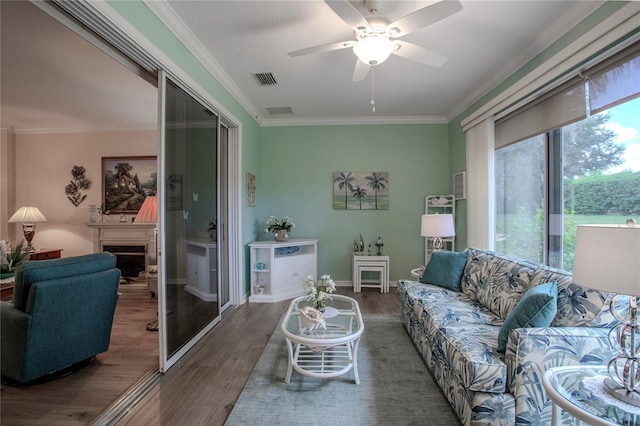 living room with ornamental molding, dark hardwood / wood-style flooring, and ceiling fan