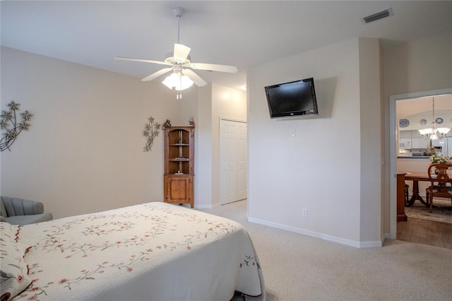 bedroom with light colored carpet, ceiling fan with notable chandelier, and a closet