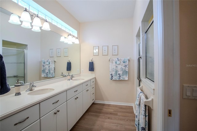 bathroom featuring hardwood / wood-style flooring, vanity, and a shower with shower door