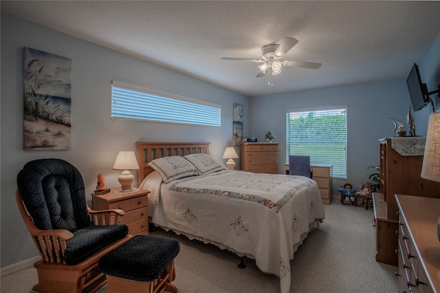 carpeted bedroom featuring a textured ceiling and ceiling fan