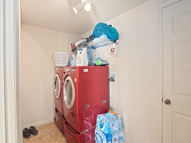 washroom featuring baseboards, separate washer and dryer, light tile patterned flooring, and laundry area