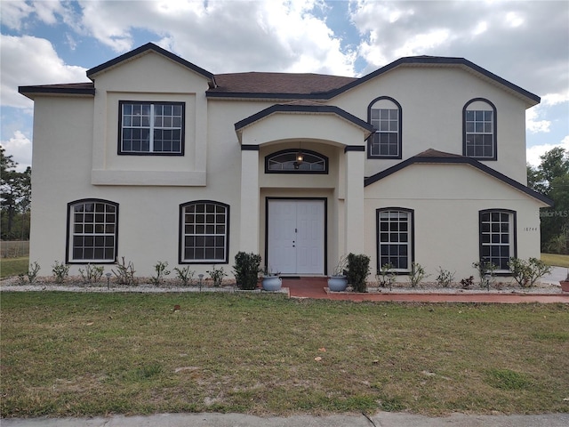 traditional home featuring a front lawn and stucco siding