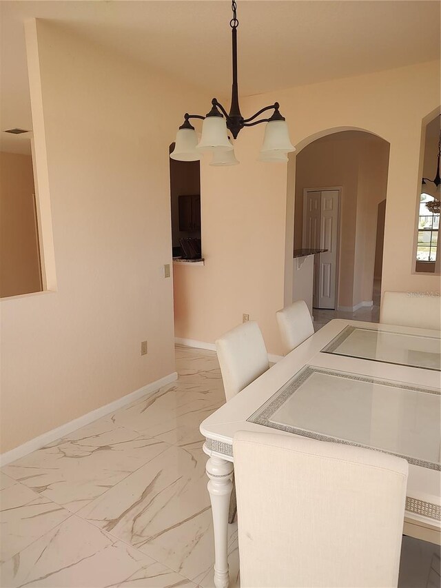 18744 Sabal St, Orlando, FL 32833 - dining area with light marble finish floors, arched walkways, and baseboards