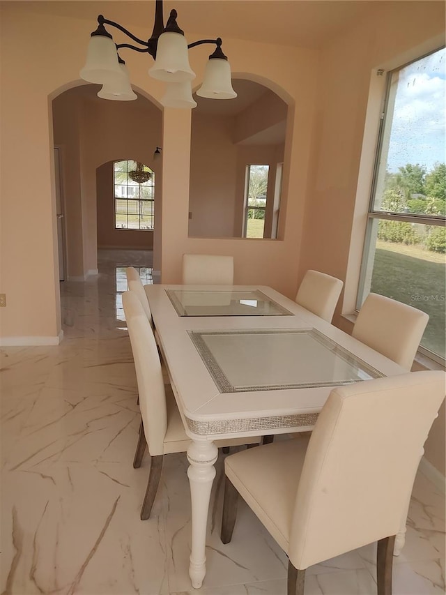 18744 Sabal St, Orlando, FL 32833 - dining room featuring arched walkways, light marble finish floors, healthy amount of natural light, and baseboards