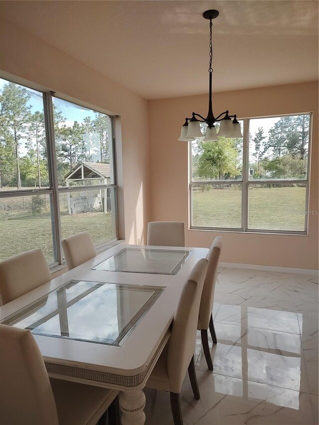 18744 Sabal St, Orlando, FL 32833 - dining area featuring light marble finish flooring, a chandelier, and baseboards