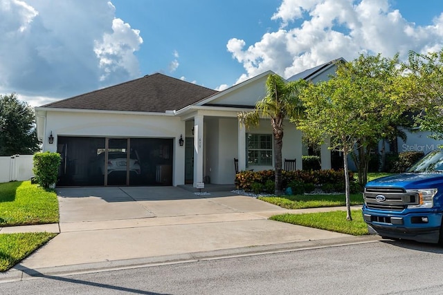 view of front facade featuring stucco siding, roof with shingles, concrete driveway, and a garage