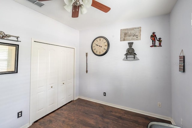 unfurnished bedroom with dark wood finished floors, a closet, ceiling fan, baseboards, and visible vents