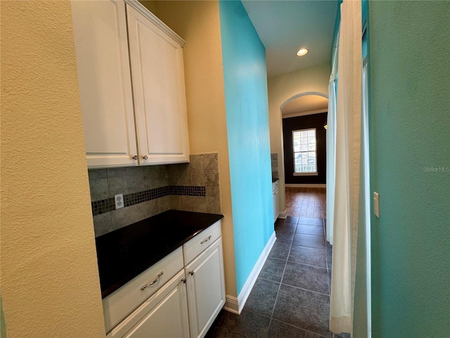 hallway featuring dark tile patterned floors