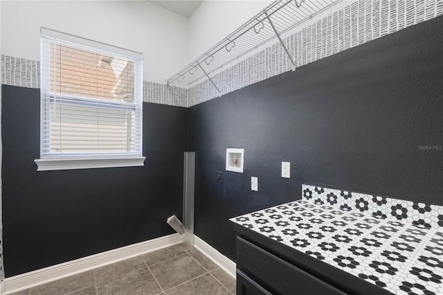 laundry area with dark tile patterned flooring and hookup for a washing machine