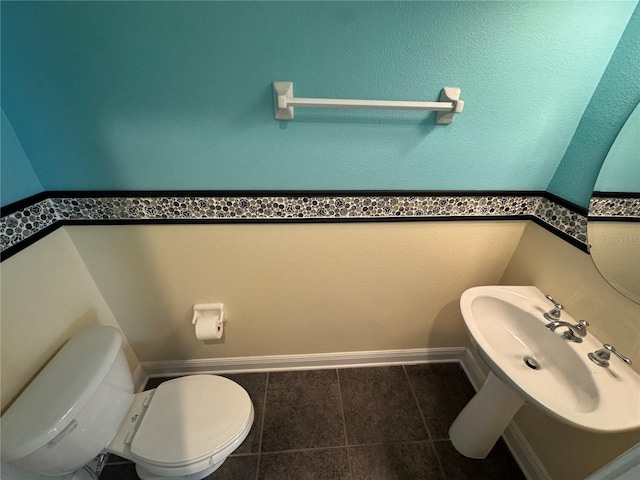 bathroom featuring sink, toilet, and tile patterned flooring