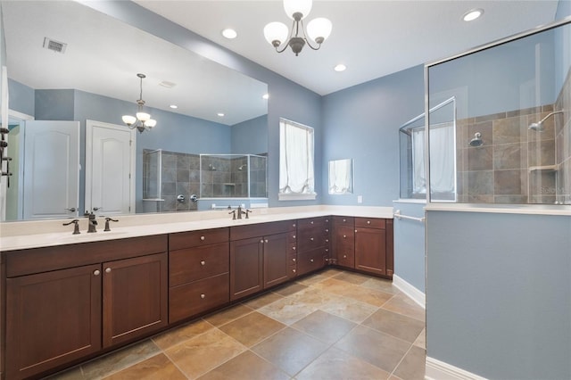 bathroom featuring vanity, an inviting chandelier, and a tile shower